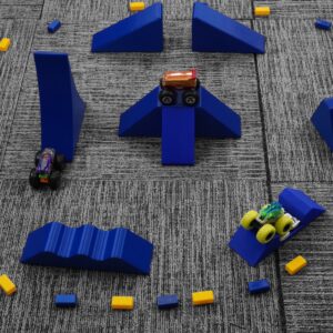 An image showcasing the Monster Truck Track Jam Course Set with seven different obstacles designed for 1/64 scale Monster Trucks. The course is compatible with popular brands like Hot Wheels and Monster Jam trucks, made from environmentally friendly PLA plastic by a small business in the USA, suitable for both indoor and outdoor use