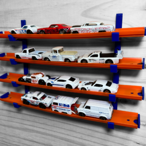 Image of a Hot Wheels Wall Display featuring orange tracks and blue brackets, mounted on a wooden wall. The display holds several Hot Wheels cars, showcasing a neat and organized collection